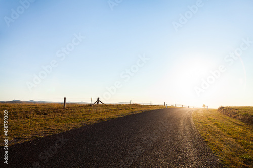Rural country road towards the sunset and big open sky