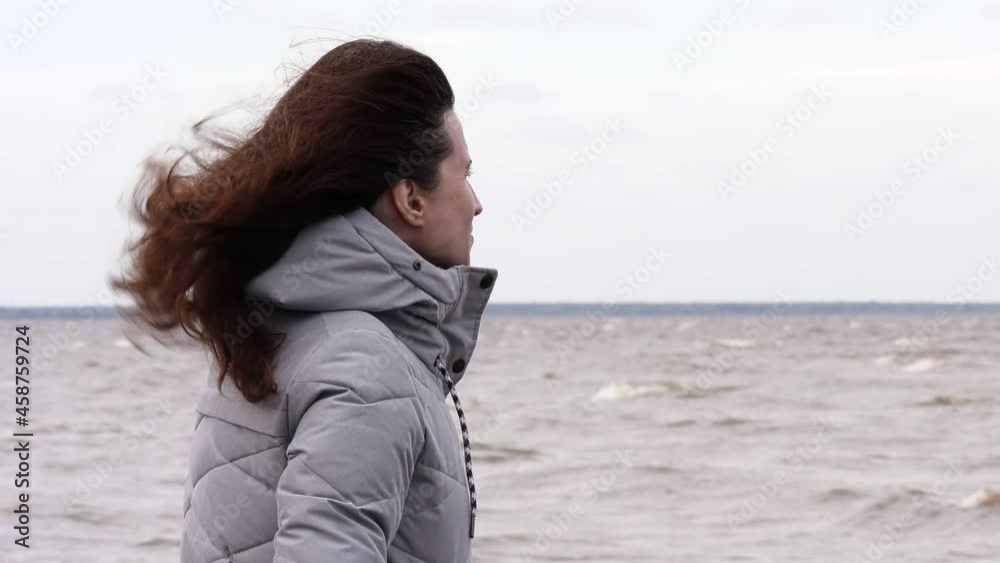 A Woman Looks at the Foamy Waves. Windy Autumn Day at the Shore of Lake Ilmen. A Woman Looks at the Foamy Waves. Windy Autumn Day at the Shore of Lake Ilmen.