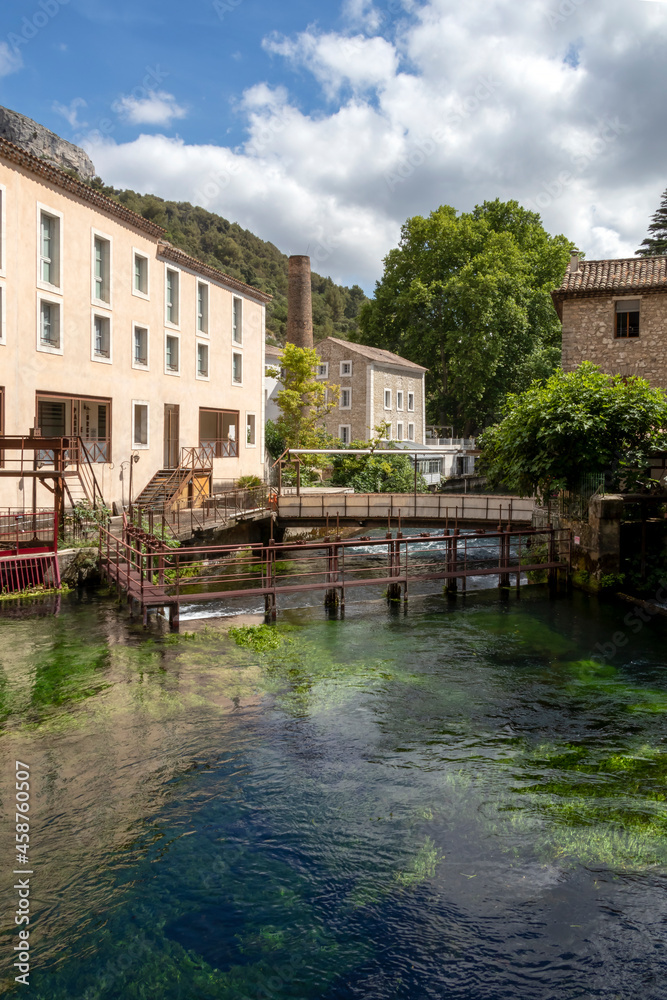 Fontaine-de-Vaucluse old town with river Sorgue in the foreground, charming medieval village in Vaucluse, Provence, southern France