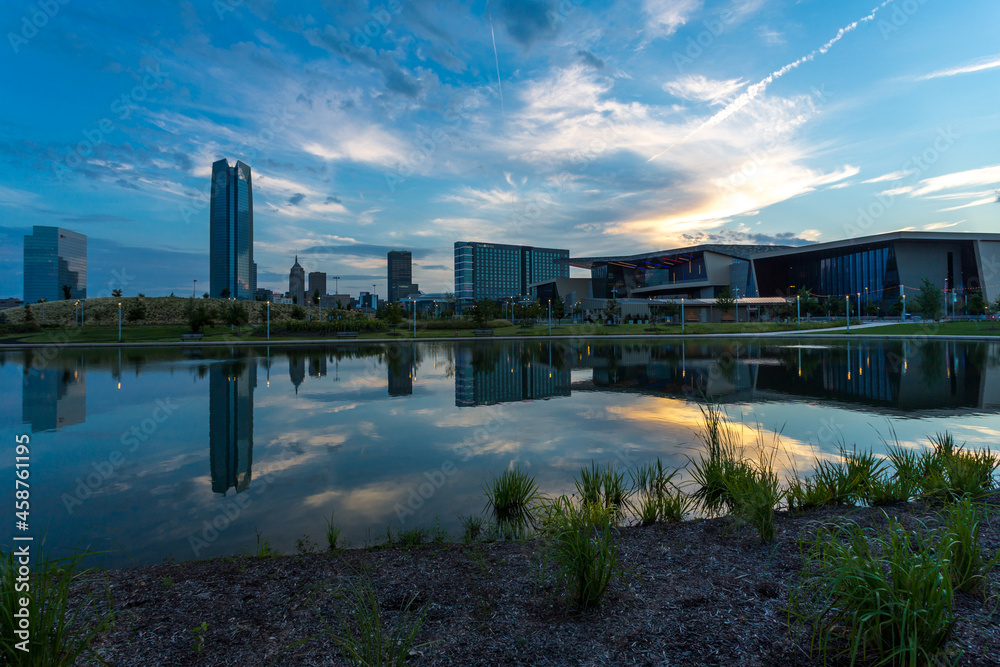 Oklahoma City downtown buildings reflect in a pond water in morning light