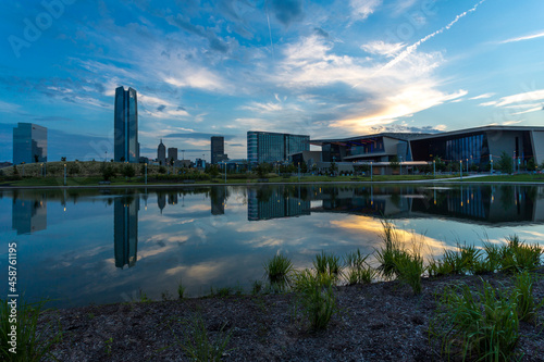 Oklahoma City downtown buildings reflect in a pond water in morning light