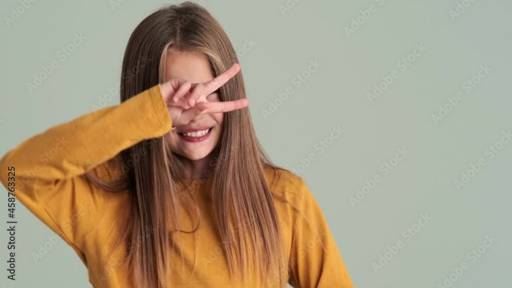A happy small girl dancing isolated over gray wall in the studio A happy small girl dancing isolated over gray wall in the studio