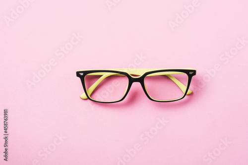 Modern spectacles eye glass or eyeglasses isolated on pink background. Top view. Banner. Mock up.