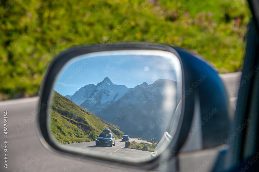 Road to a mountain peak, view from the car side mirror.