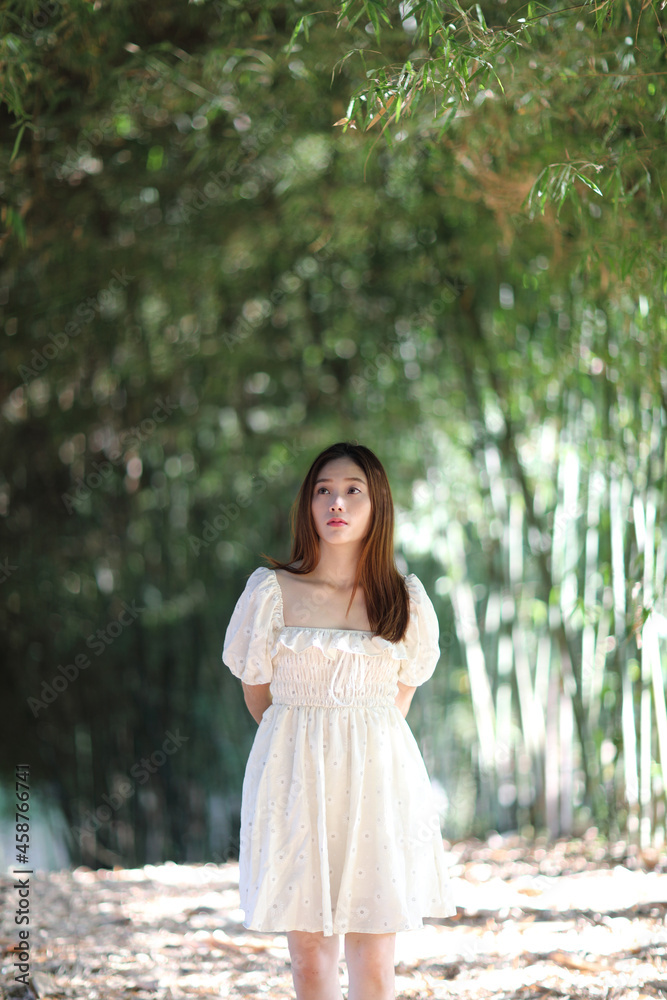 Beautiful young woman with white dress on bamboo forest background Beautiful young woman with white dress on bamboo forest background