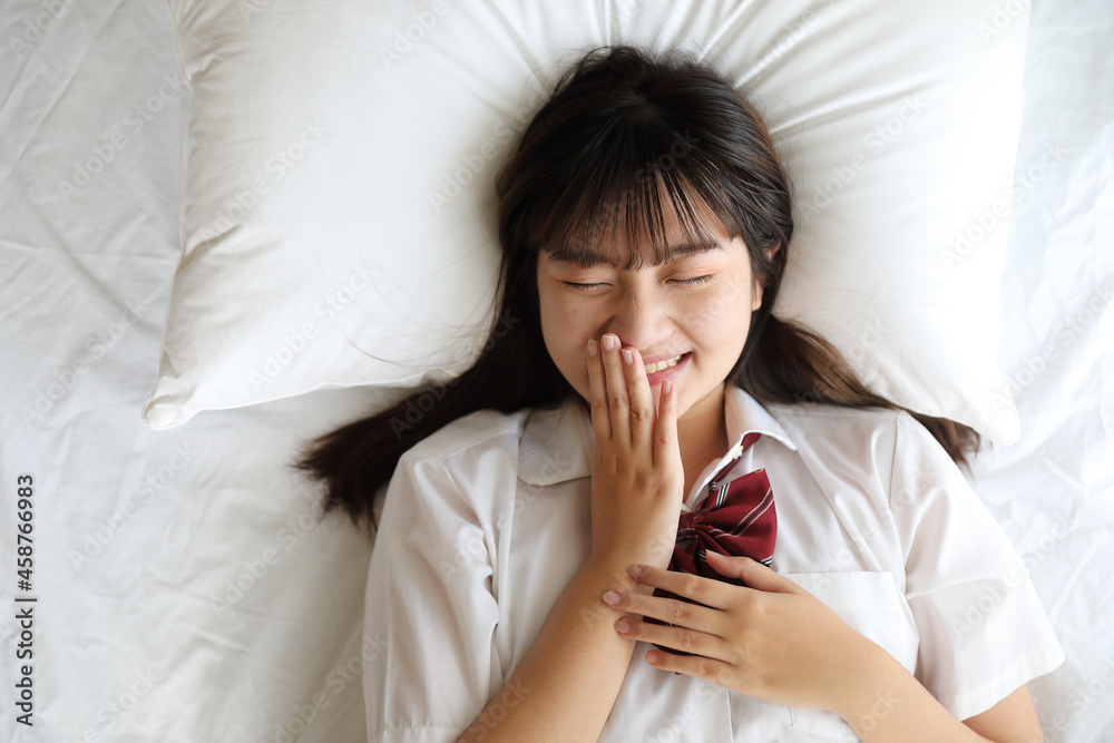 Portrait japanese school girl uniform sleep and look at camera in white tone bed room Portrait japanese school girl uniform sleep and look at camera in white tone bed room