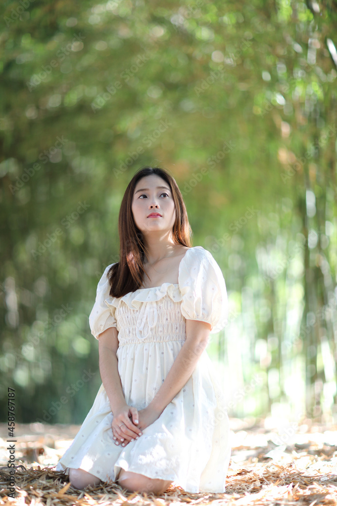 Beautiful young woman with white dress on bamboo forest background Beautiful young woman with white dress on bamboo forest background