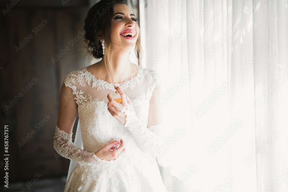 Gorgeous bride in robe posing and preparing for the wedding ceremony face in a room
