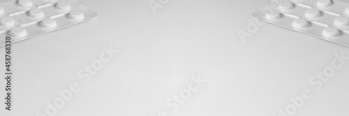 White medical background with sachets of tablets on the sides of the image