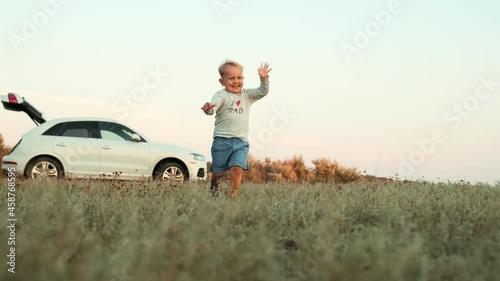 Bottom view of a little cheerful boy running forward in nature photo