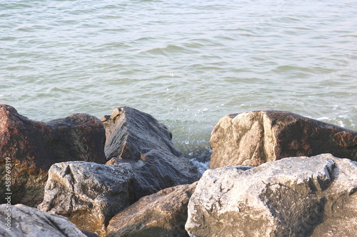 Large stones close-up in sea water in summer on beach against background of sea