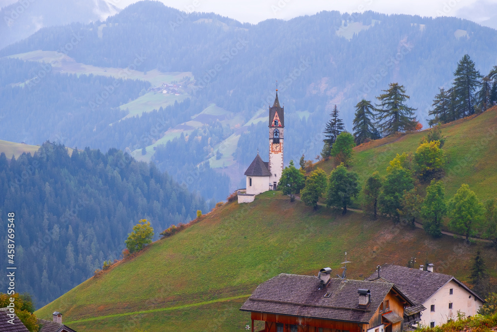 Church of Santa Barbara in the cozy little village of La Valle on a foggy morning, Alta Badia, South Tyrol