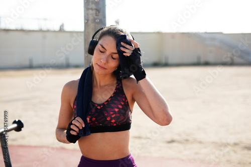 Beautiful athlete woman listening the music. Young fit woman preparing for the training.