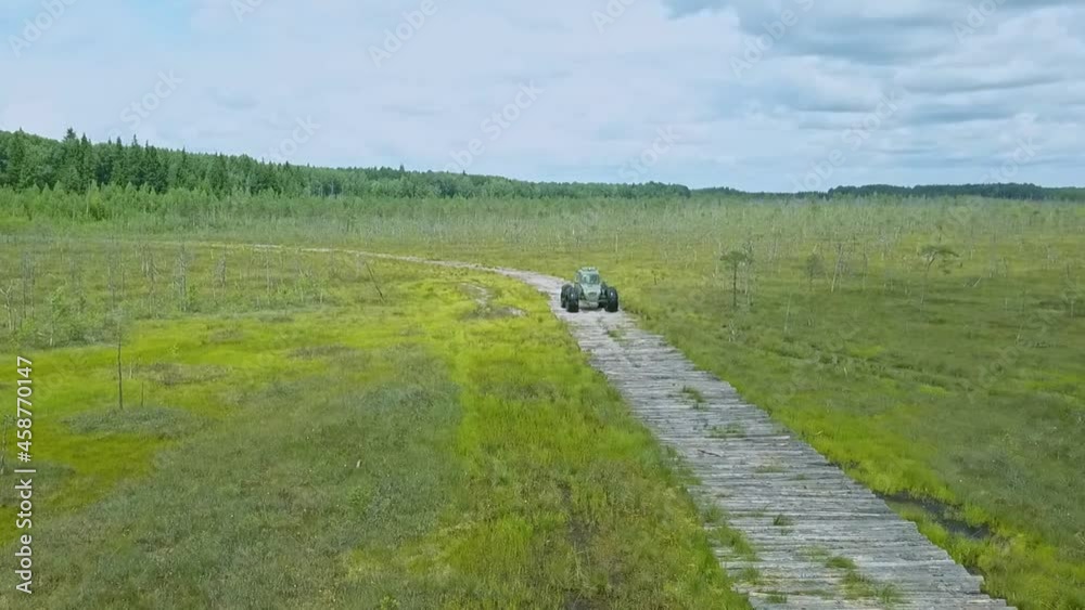Special off road car with low ground pressure wheels and tires for a hard to access areas. Extreme all-terrain vehicle. Ecological transport for swamp on dramatic sky background. Special off road car with low ground pressure wheels and tires for a hard to access areas. Extreme all-terrain vehicle. Ecological transport for swamp on dramatic sky background.