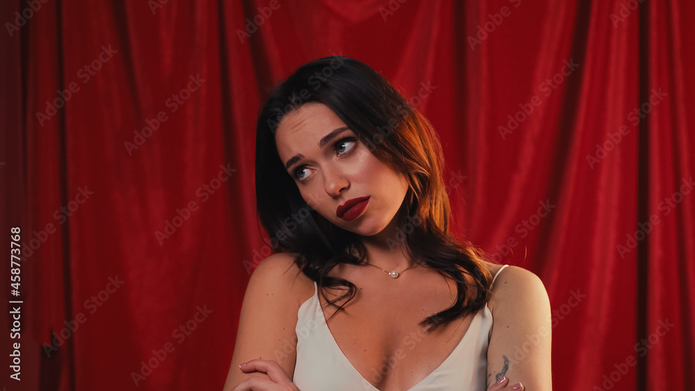 young and sad woman looking away on red. young and sad woman looking away on red.