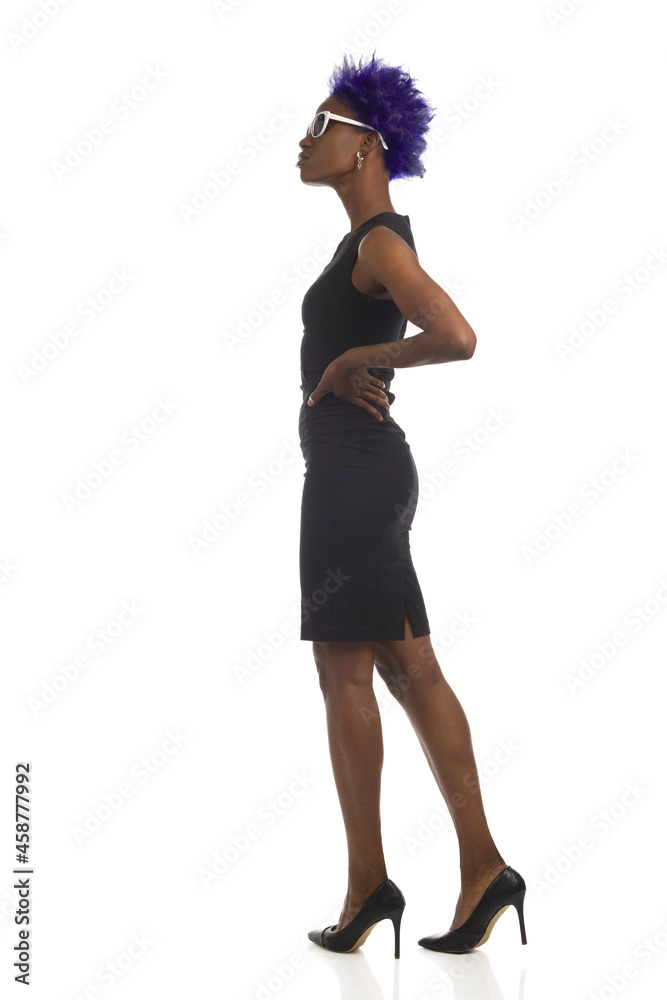 Beautiful Black Woman In Sunglasses, Mini Dress And High Heels Is Standing And Looking Away. Side View, Full Length, Isolated.