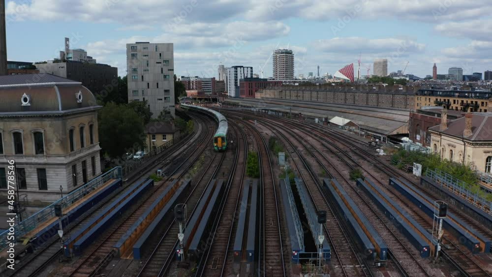 Backwards tracking of passenger train driving on wide multitrack railway bridge over river. London, UK Backwards tracking of passenger train driving on wide multitrack railway bridge over river. London, UK