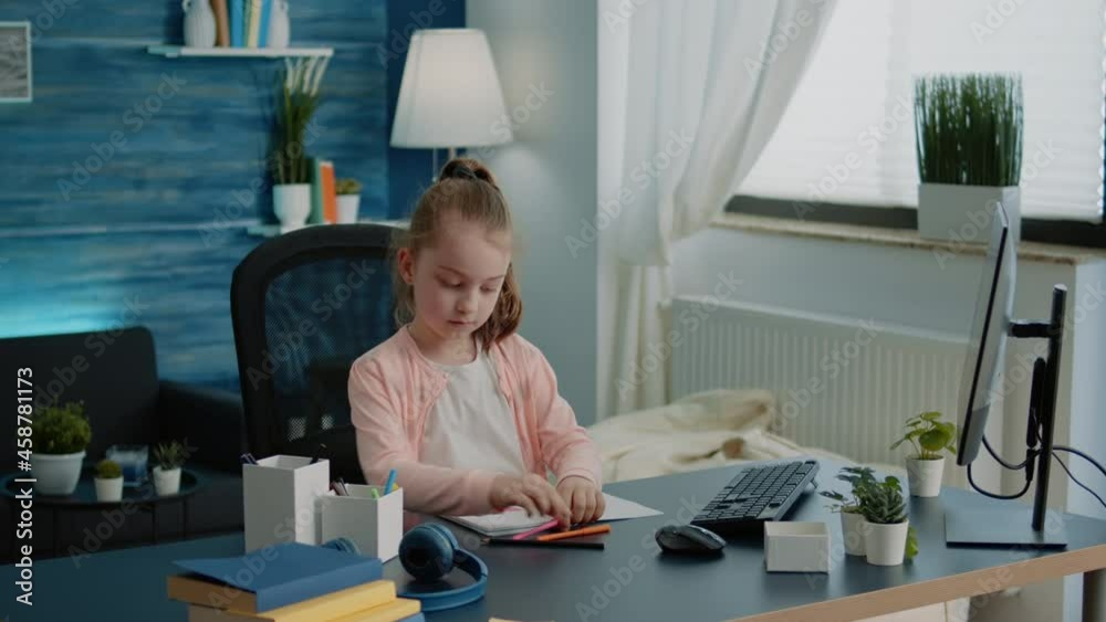 Little girl drawing on notebook with colorful pencils. Child enjoying fun activity after remote lessons and homework. Pupil finishing school classes on internet to draw for entertainment Little girl drawing on notebook with colorful pencils. Child enjoying fun activity after remote lessons and homework. Pupil finishing school classes on internet to draw for entertainment