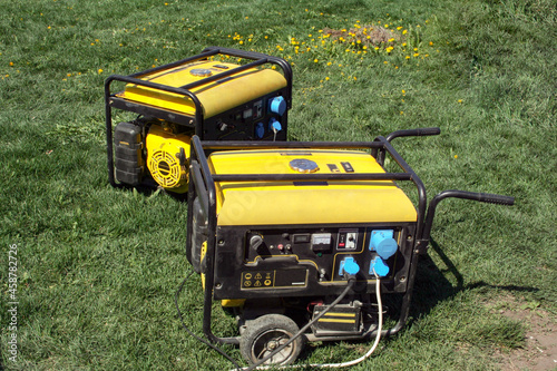 Autonomous portable yellow diesel generator stands on the grass