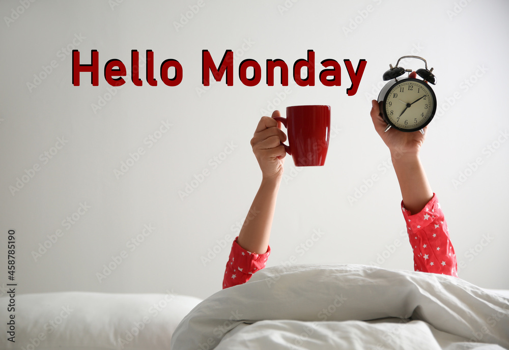 Hello Monday, start your week with good mood. Closeup view of woman with cup and alarm clock lying in bed - obrazy, fototapety, plakaty 