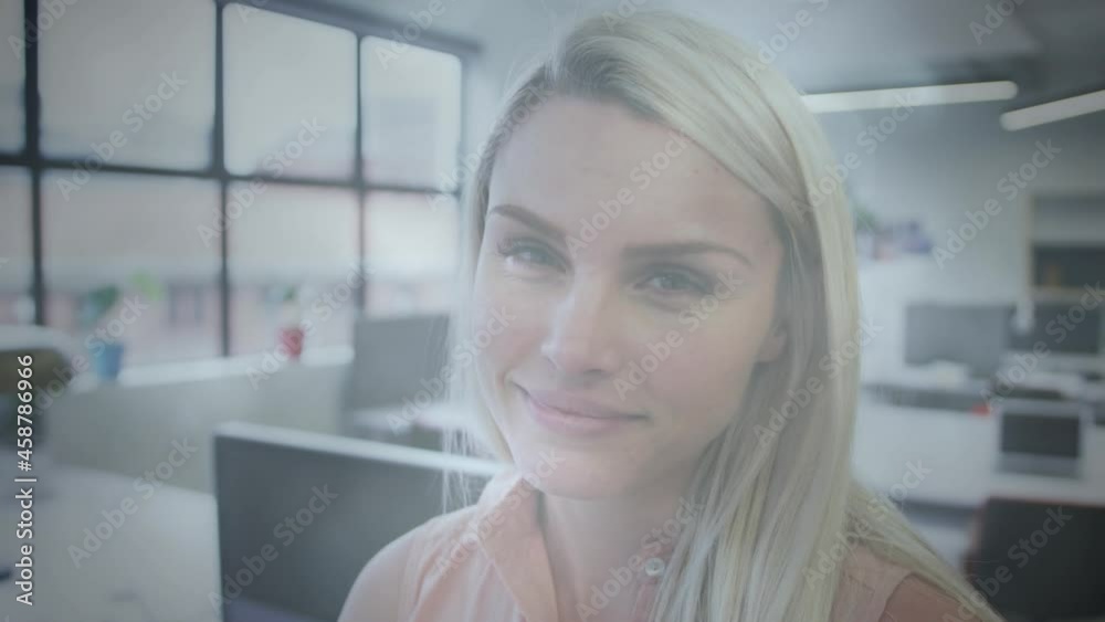 Animation of light spots over smiling caucasian businesswoman in office Animation of light spots over smiling caucasian businesswoman in office
