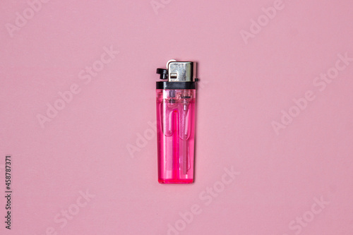 Pink lighter on a pink background. Cheap plastic lighter photo