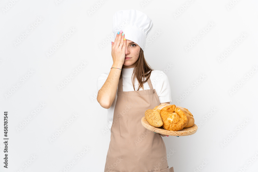 Young woman in chef uniform isolated on white background covering a eye by hand Young woman in chef uniform isolated on white background covering a eye by hand