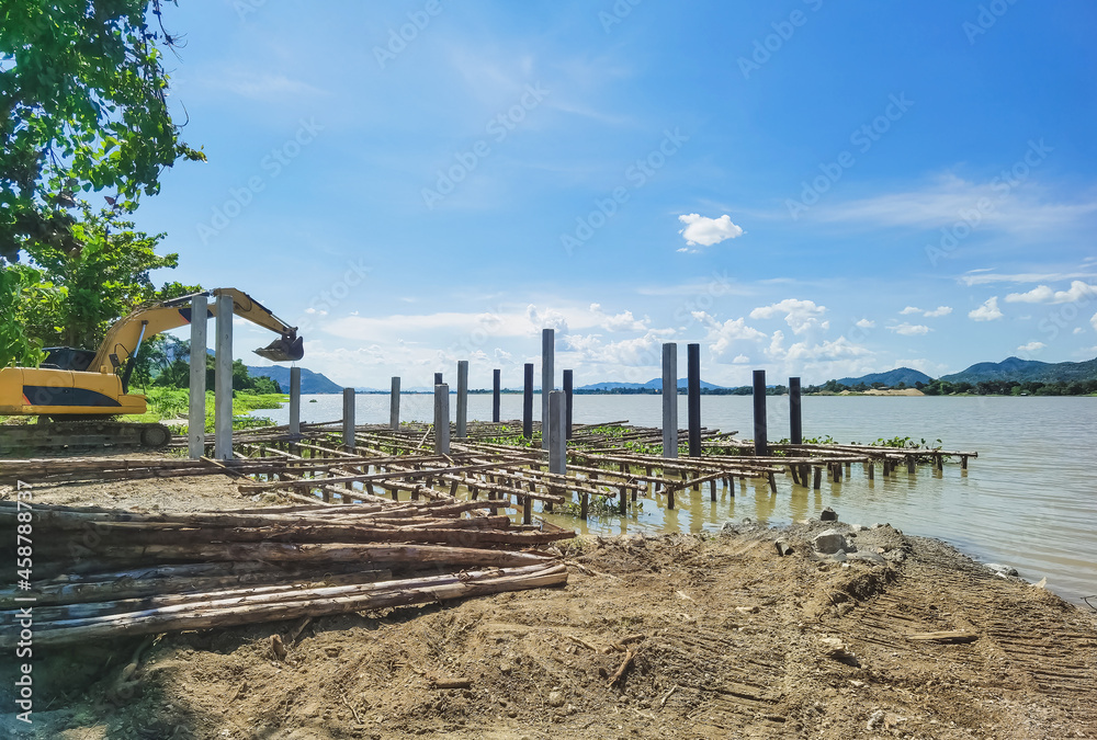The construction of a small jetty for the convenience of boarding and landing jet skis along the river. Build a berth that juts out into the river with beams made of logs and cement columns.