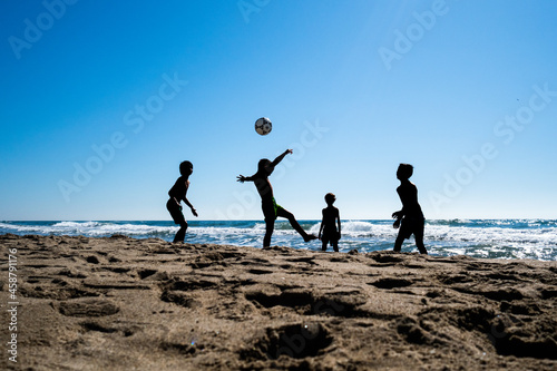 Young boys playing football on the beach in Marbella, Spain photo