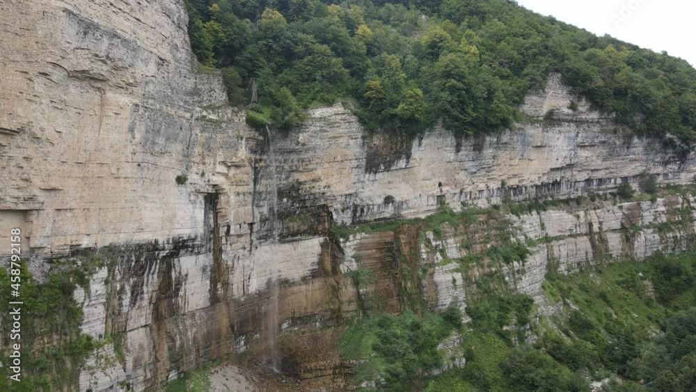 Scenic view of huge Okatse waterfall in Georgia touristic landmark in summer day Scenic view of huge Okatse waterfall in Georgia touristic landmark in summer day