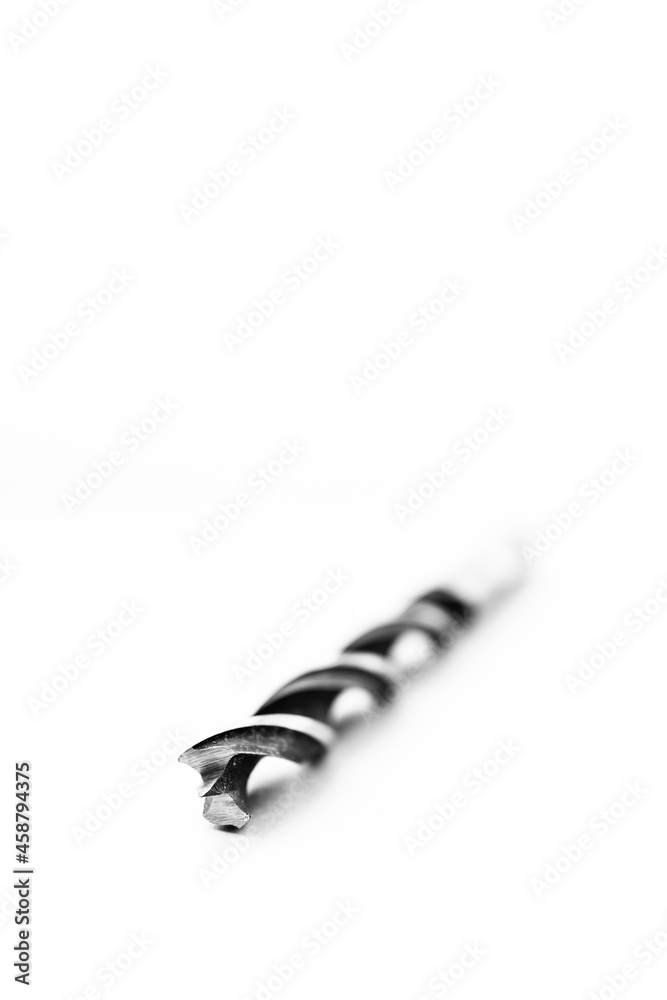A black and white studio portrait of a spiral high speed steel wood drill bit on a white background. The metal tool is used to drill holes into wood for repair or construction or build work. A black and white studio portrait of a spiral high speed steel wood drill bit on a white background. The metal tool is used to drill holes into wood for repair or construction or build work.