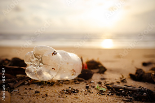 Trash bottles dumped on the sandy beach during the monsoon sea.