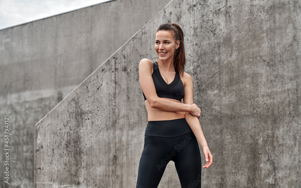 Fototapeta premium Young cheerful woman wear black sport suit
