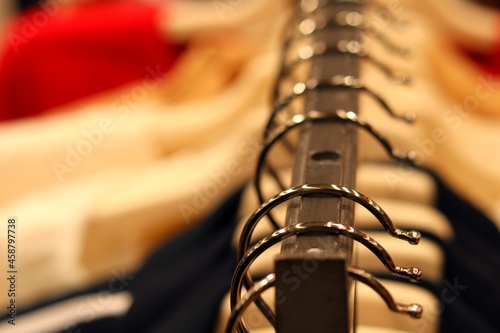 Hangers with clothes on the counter in the store, close-up, macro, blurred background