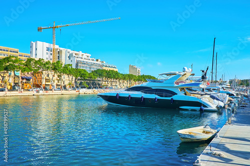 Moored yachts in Valletta marina with a view on the seaside promenade of Ta'Xbiex town, Malta. photo