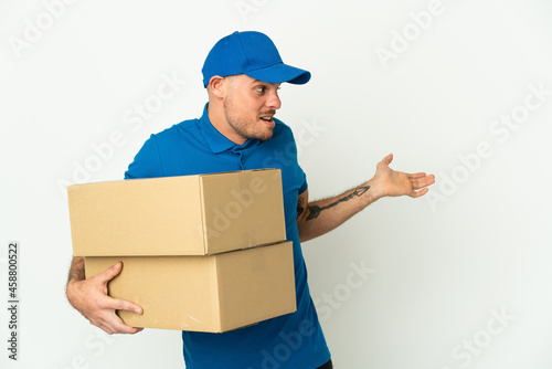 Delivery caucasian man isolated on white background with surprise expression while looking side