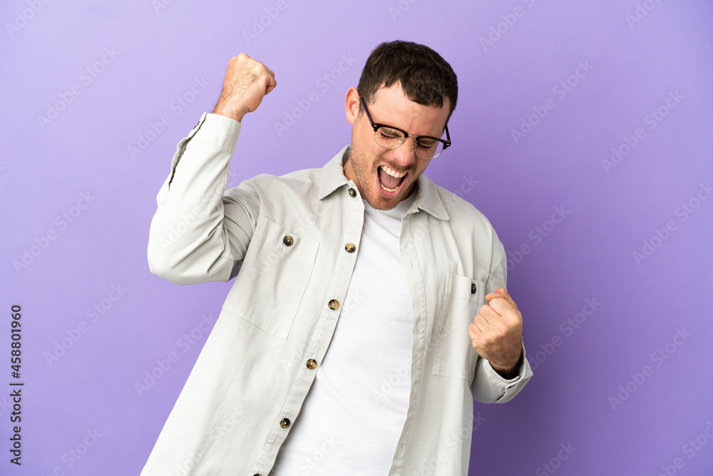 Brazilian man over isolated purple background celebrating a victory Brazilian man over isolated purple background celebrating a victory