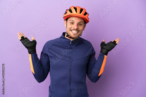 Young Brazilian cyclist man isolated on purple background with shocked facial expression © luismolinero