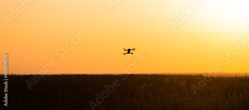 The drone is in flight at sunset . Video shooting from above. An article about the choice of a quadrocopter. Pros and cons of the drone.