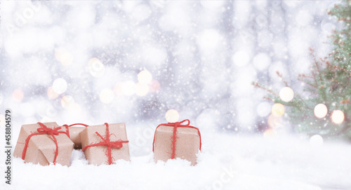 christmas presents and fir in the snow with bokeh and copy space