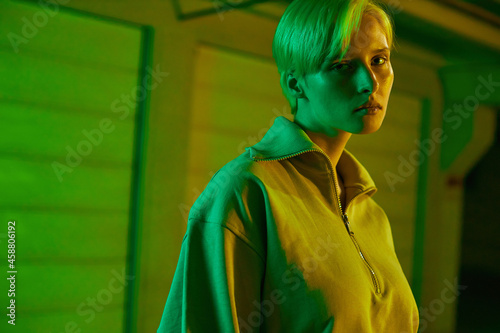 creative portrait of a girl with short hair in neon green. Bright modern shooting. High quality photo
