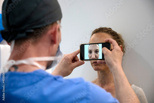 Aesthetic surgeon taking photograph of patient before operation