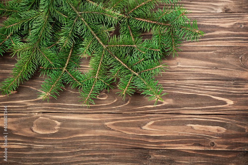 Fir branches on a brown wooden background. Christmas background. Fir branches on a brown wooden background. Christmas background.