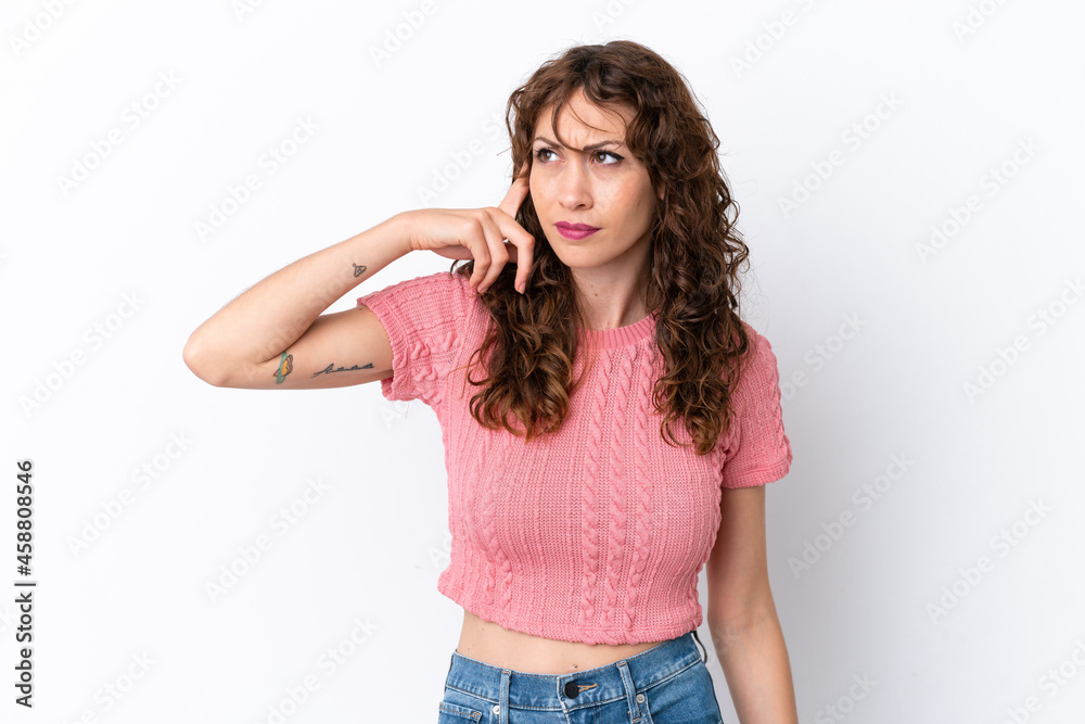 Young woman with curly hair isolated on white background making the gesture of madness putting finger on the head Young woman with curly hair isolated on white background making the gesture of madness putting finger on the head
