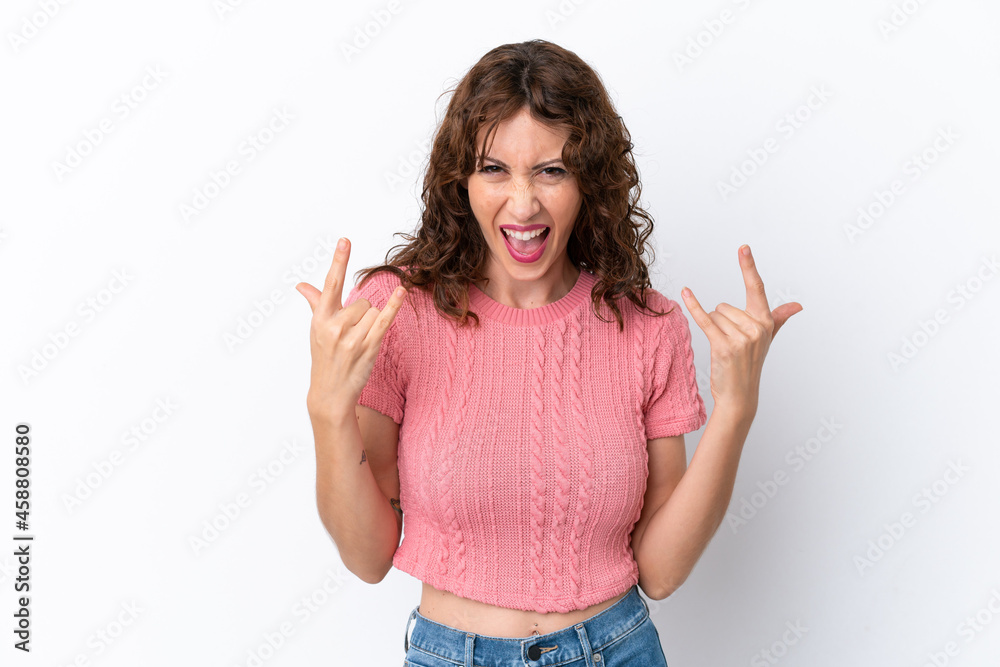 Young woman with curly hair isolated on white background making horn gesture Young woman with curly hair isolated on white background making horn gesture