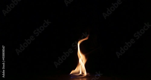 A single flame on a black background.