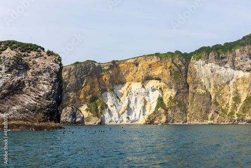Cliffs of the steep coast of the Pacific Ocean in Kamchatka, interesting geological structures of the cliff.