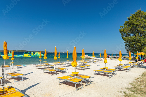 closed beach umbrellas and empty sunbeds