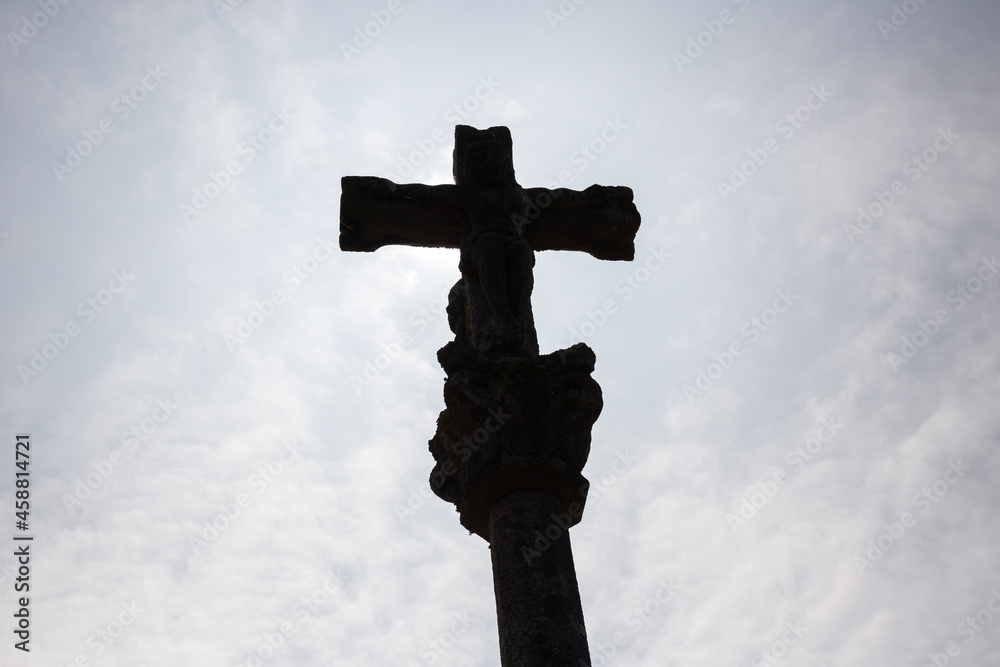 Stone cross called cruceiro against blue sky, Galicia, Spain
