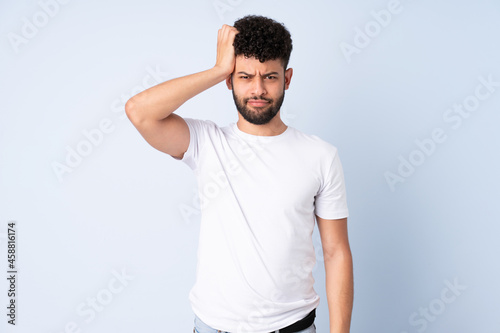 Young Moroccan man isolated on blue background with an expression of frustration and not understanding